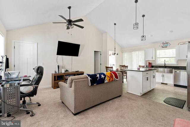 living area with high vaulted ceiling, ceiling fan with notable chandelier, and light colored carpet