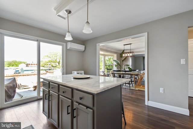 1003 E Cherry St, Palmyra, PA 17078 - kitchen featuring a wall mounted AC, dark wood-style floors, gray cabinets, pendant lighting, and light stone counters