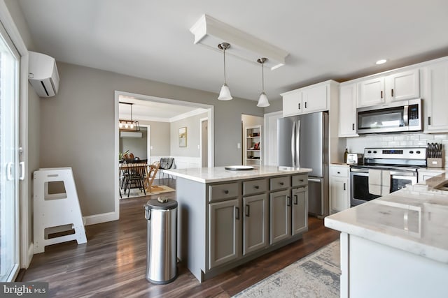 1003 E Cherry St, Palmyra, PA 17078 - kitchen with dark wood-style flooring, gray cabinetry, a wall unit AC, stainless steel appliances, and pendant lighting