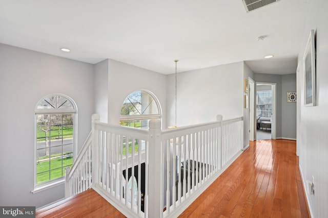 hallway featuring baseboards, recessed lighting, an upstairs landing, visible vents, and hardwood / wood-style flooring