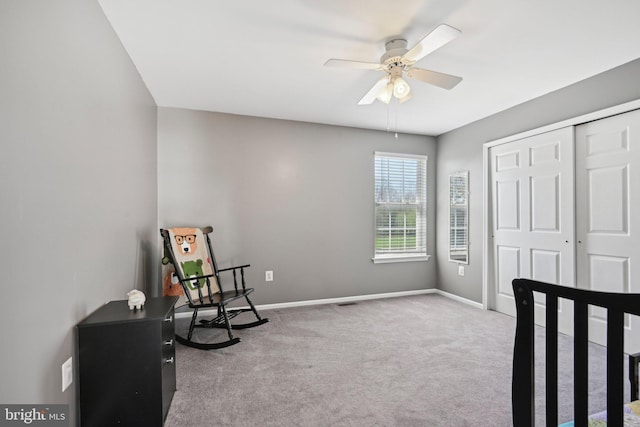 living area with carpet floors, baseboards, and a ceiling fan