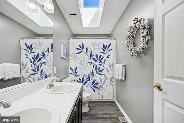 full bathroom with visible vents, a sink, toilet, and a skylight