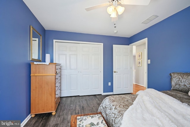 bedroom with a closet, baseboards, a ceiling fan, visible vents, and wood finished floors