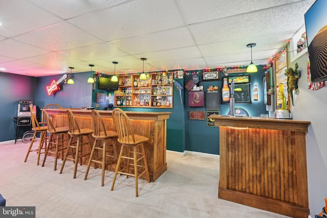 bar with a paneled ceiling, baseboards, indoor bar, and carpet floors