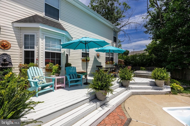 deck with a jacuzzi and fence