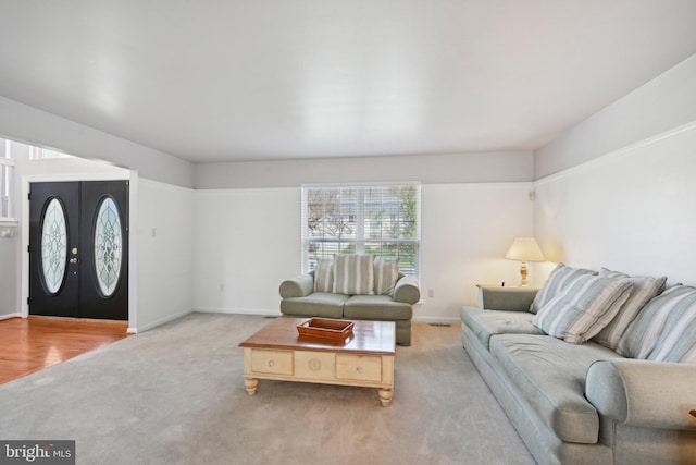 carpeted living area featuring baseboards