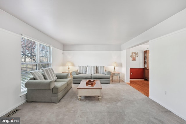 carpeted living room featuring visible vents and baseboards