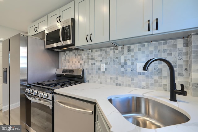 4108 Rokeby Rd, Baltimore, MD 21229 - kitchen with decorative backsplash, light stone countertops, a sink, and stainless steel appliances