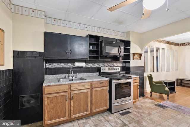 kitchen featuring stainless steel electric range, open shelves, a sink, black microwave, and brown cabinetry