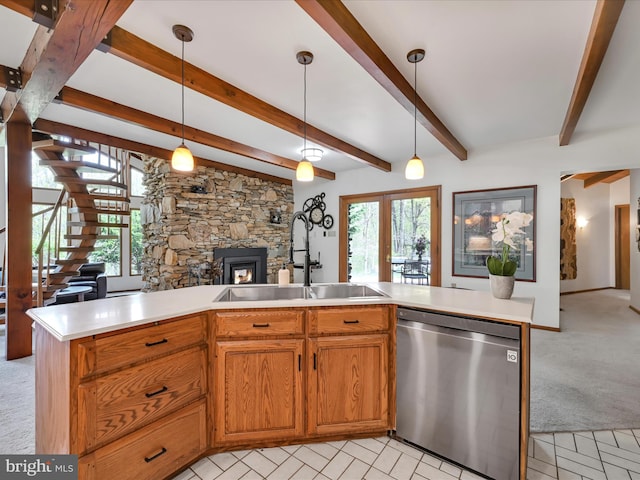 kitchen featuring light carpet, a sink, dishwasher, open floor plan, and a wealth of natural light