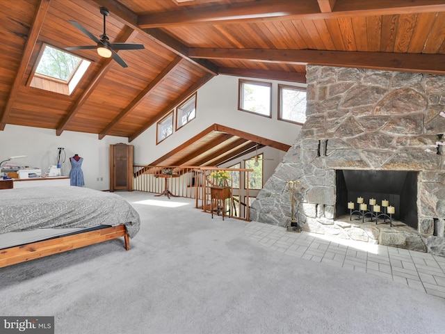 bedroom with carpet floors, wooden ceiling, lofted ceiling with skylight, and a fireplace