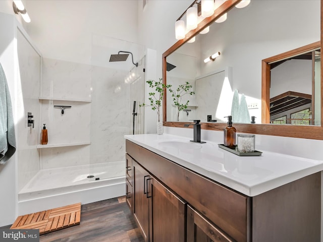 bathroom featuring vanity, a walk in shower, and wood finished floors