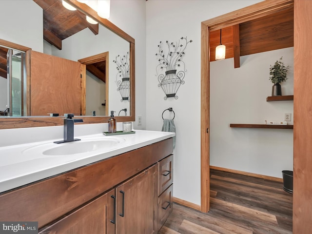 bathroom with vanity, baseboards, and wood finished floors