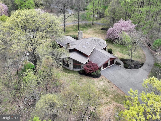 bird's eye view with a wooded view