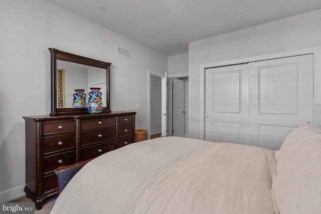 bedroom featuring baseboards, visible vents, and a closet