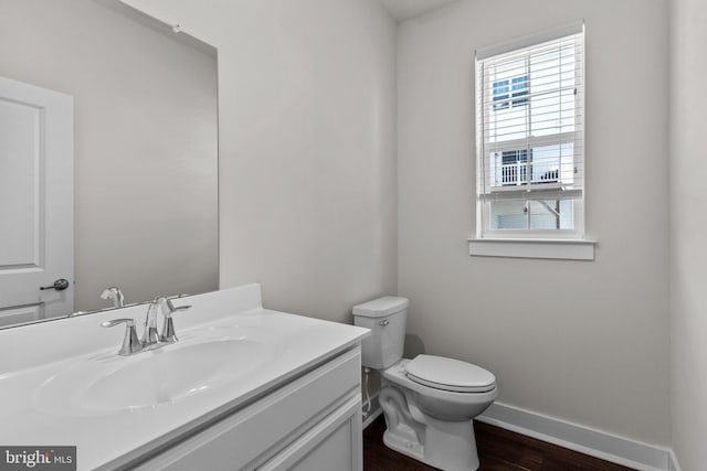 bathroom featuring baseboards, plenty of natural light, wood finished floors, and toilet