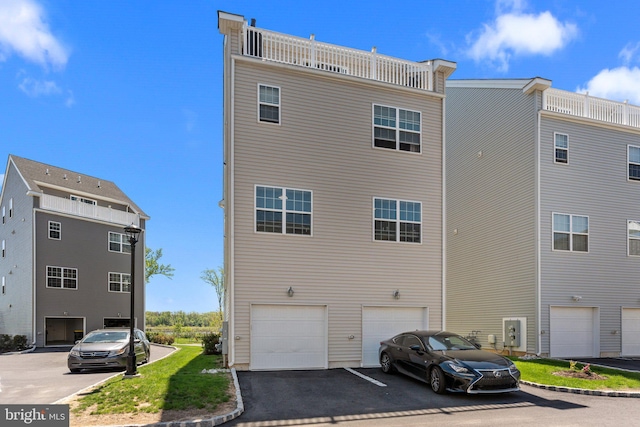 rear view of house featuring an attached garage and driveway