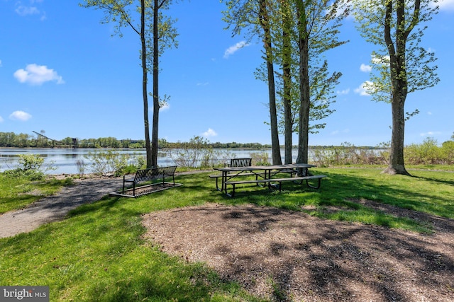 surrounding community featuring a lawn and a water view