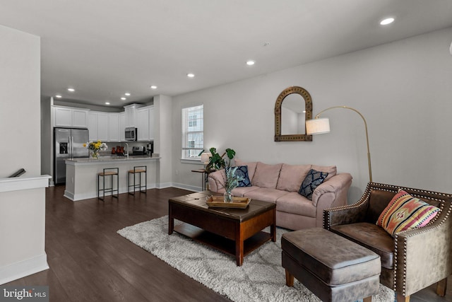 living room with dark wood-style flooring, recessed lighting, and baseboards