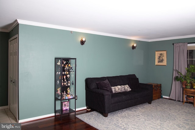 living area with baseboards, wood finished floors, and crown molding