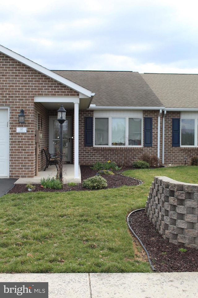 197 Parkwood Dr Unit 320, Chambersburg, PA 17201 - doorway to property with brick siding, a garage, roof with shingles, and a yard