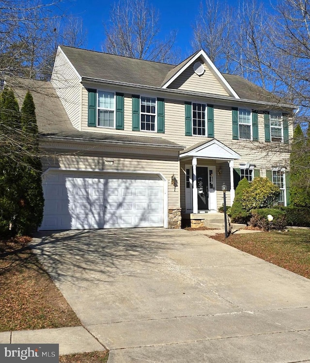view of front of house featuring stone siding, a garage, and concrete driveway