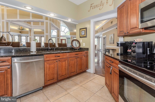 kitchen featuring brown cabinetry, a healthy amount of sunlight, appliances with stainless steel finishes, and a sink