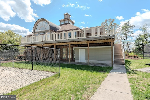 back of house with fence, a wooden deck, roof with shingles, and a yard