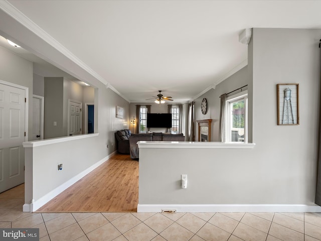 kitchen with crown molding, a ceiling fan, a healthy amount of sunlight, and light tile patterned flooring