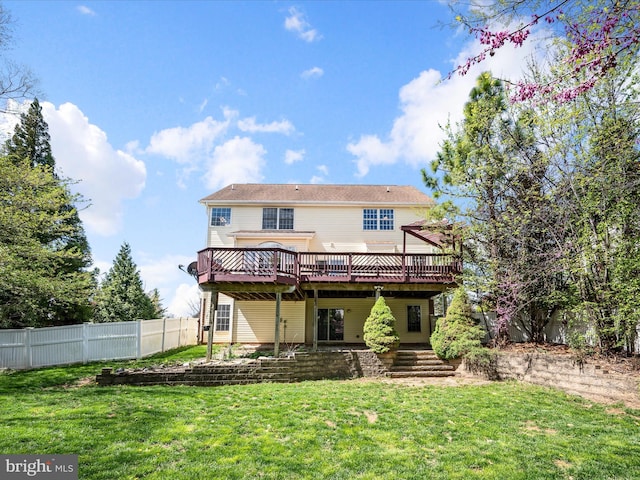 back of property featuring a wooden deck, a lawn, and fence