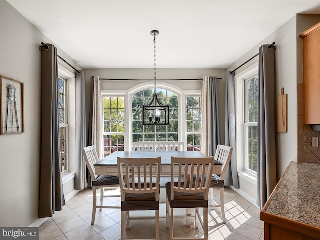 dining area with a notable chandelier, a healthy amount of sunlight, and light tile patterned flooring
