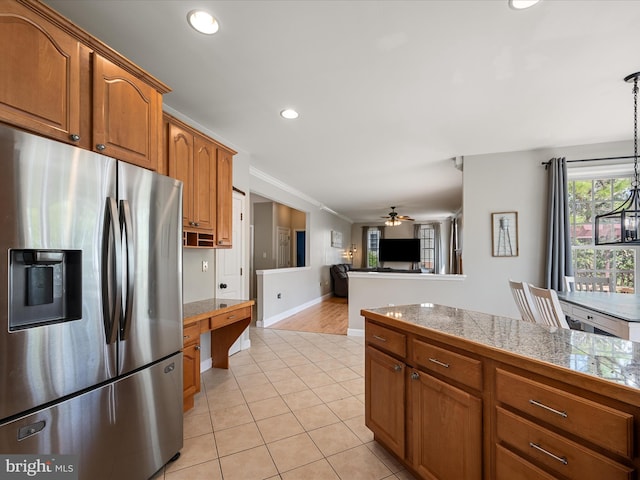 kitchen with a ceiling fan, tile countertops, brown cabinetry, stainless steel fridge, and recessed lighting