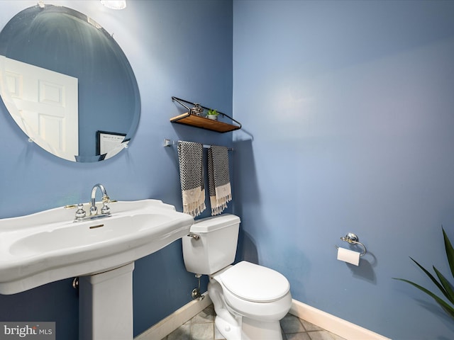 half bath with baseboards and toilet