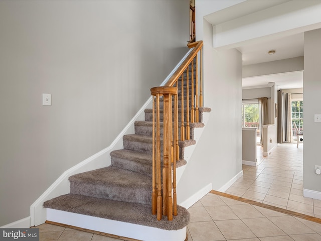 stairway featuring baseboards and tile patterned floors