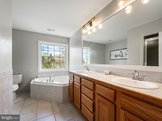 full bathroom with tile patterned floors, toilet, a garden tub, and a sink