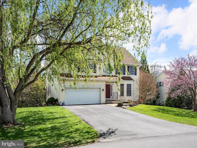 traditional home featuring a front lawn, driveway, and a garage