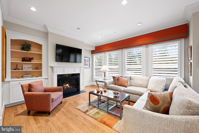 living room with a fireplace with flush hearth, light wood-style flooring, crown molding, baseboards, and recessed lighting