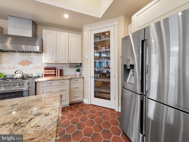 32828 Murray Rd, Frankford, DE 19945 - kitchen with white cabinetry, decorative backsplash, light stone countertops, appliances with stainless steel finishes, and wall chimney exhaust hood