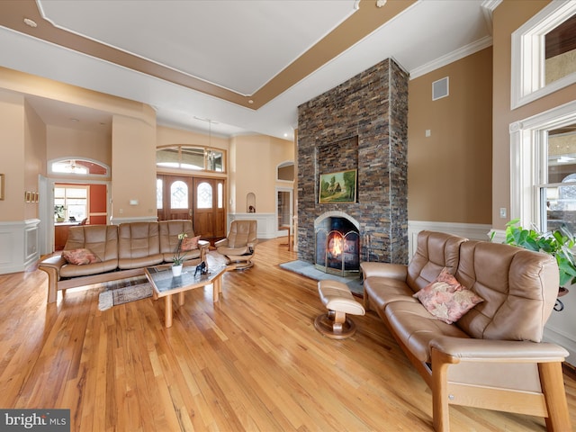 32828 Murray Rd, Frankford, DE 19945 - living room with a wainscoted wall, a decorative wall, visible vents, a stone fireplace, and hardwood / wood-style floors