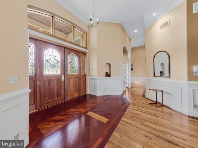32828 Murray Rd, Frankford, DE 19945 - entrance foyer featuring a wainscoted wall, visible vents, crown molding, and wood finished floors