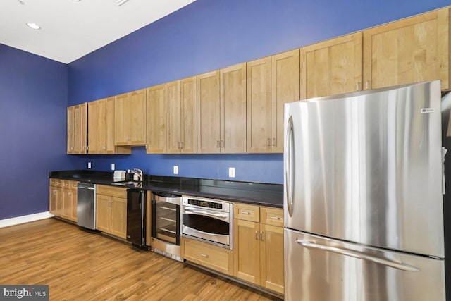 414 Water St Unit 1802, Baltimore, MD 21202 - kitchen featuring wine cooler, wood finished floors, appliances with stainless steel finishes, light brown cabinets, and dark countertops
