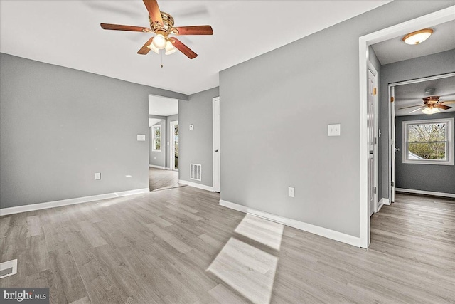 unfurnished room with baseboards, ceiling fan, visible vents, and wood finished floors