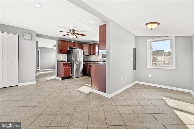 kitchen featuring light tile patterned floors, backsplash, a ceiling fan, and freestanding refrigerator