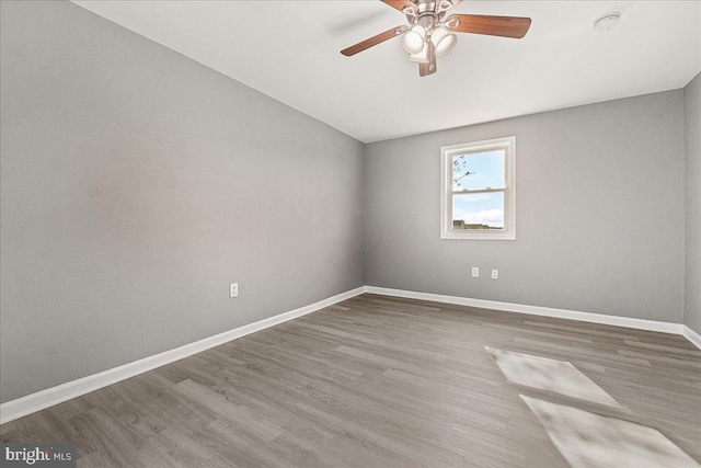 unfurnished room with baseboards, ceiling fan, and wood finished floors