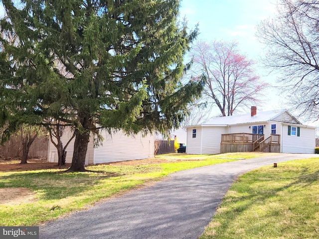 view of home's exterior featuring driveway, fence, and a yard