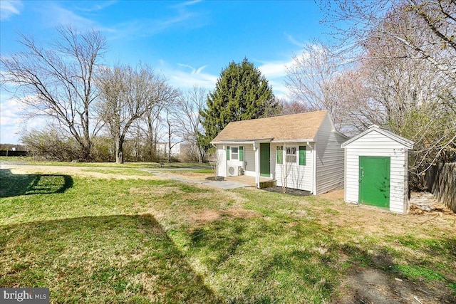 view of front of home featuring an outdoor structure and a front yard