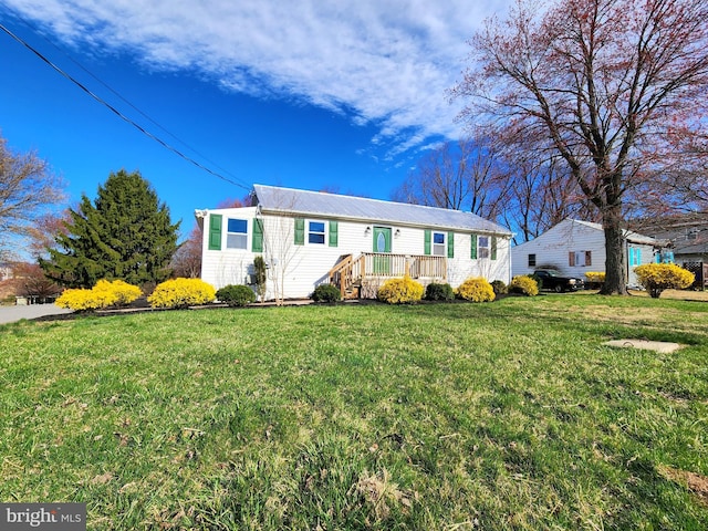 view of front of home featuring a front yard and metal roof