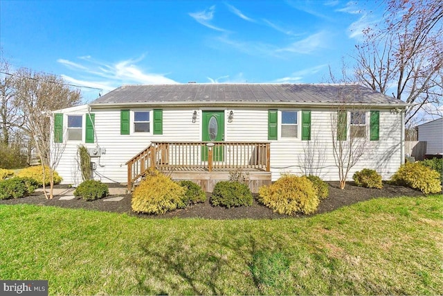 single story home with a front yard and metal roof