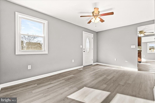 foyer entrance with ceiling fan, wood finished floors, and a healthy amount of sunlight