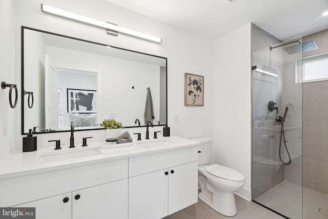 full bathroom featuring toilet, a sink, double vanity, and a walk in shower